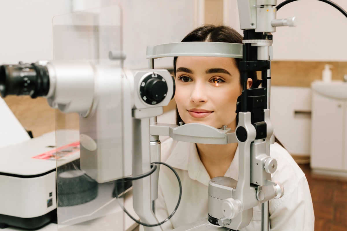 Woman receiving a slit lamp eye exam in an optometry clinic.