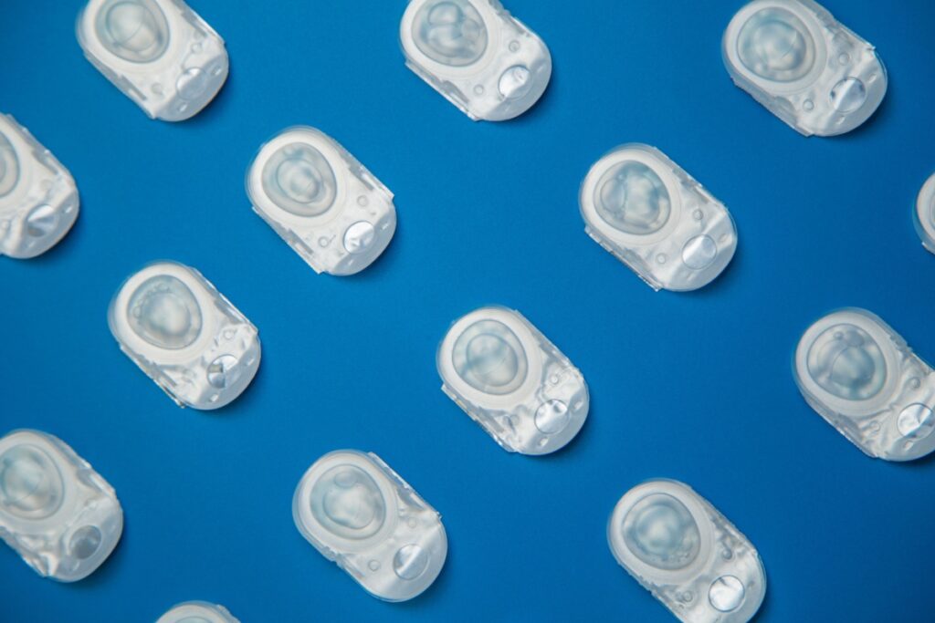Single use contact lenses arranged diagonally across a blue background.
